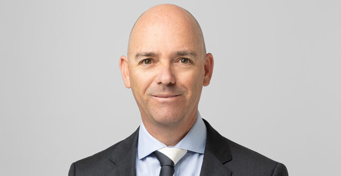 Head and shoulders shot of a smiling Darren Miller wearing a suit and tie (ARENA)